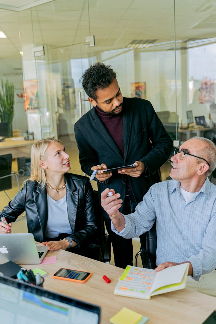 Three professionals discussing ideas in a modern office setting.